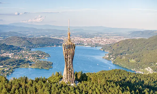 Panoramaaussicht mit Pyramidenkogel im Vordergrund beim Urlaub am Wörthersee mit weitem Blick über den See und Klagenfurt im Hintergrund