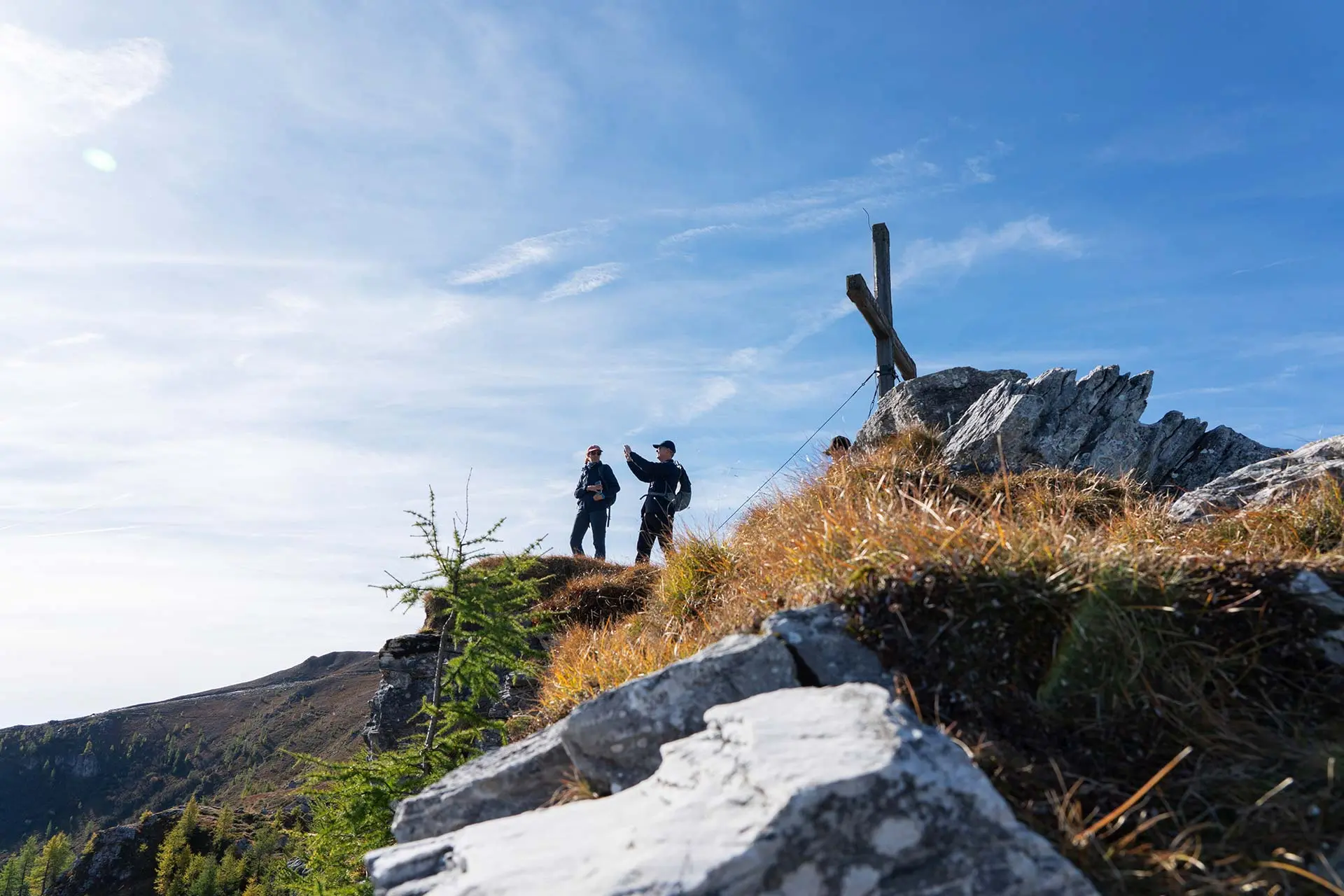 Hiker at summit cross during hiking vacation at Lake Wörthersee